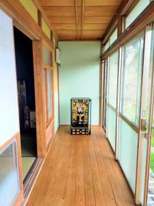 an empty room with a wooden floor and windows at INASHIKI NEST in Inashiki