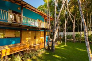 uma casa com uma varanda e um quintal em Vila Marina em Arraial d'Ajuda
