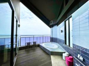 a bathroom with a tub and a view of the ocean at SKY Tower Sweet 4 Beppu, Resort Love Hotel in Beppu