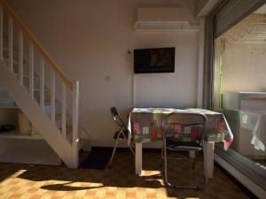 Zimmer mit einem Tisch, einem Stuhl und einer Treppe in der Unterkunft Appartement Balaruc-les-Bains, 1 pièce, 2 personnes - FR-1-553-195 in Balaruc-les-Bains