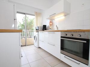 a kitchen with white appliances and a large window at Appartement T3 à Balaruc-les-Bains avec WiFi et vue sur l'étang de Thau - FR-1-553-188 in Balaruc-les-Bains