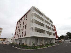 um grande edifício branco com muitas janelas em Appartement Balaruc-les-Bains, 2 pièces, 2 personnes - FR-1-553-204 em Balaruc-les-Bains