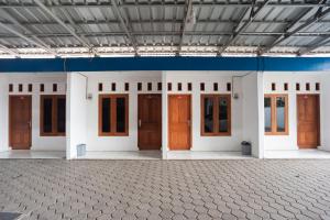 a row of doors in a building with a lot of windows at RedDoorz Syariah Plus near Jatiwarna Toll Gate in Bekasi