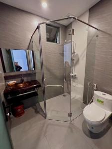 a bathroom with a shower and a toilet and a sink at Hotel Mỹ Vy in Tánh Linh