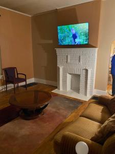 sala de estar con TV encima de la chimenea en Cozy home 5 beds private yard, en Cincinnati