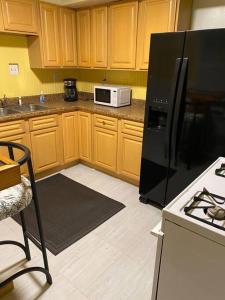 una cucina con armadi in legno e frigorifero nero di Cozy home 5 beds private yard a Cincinnati