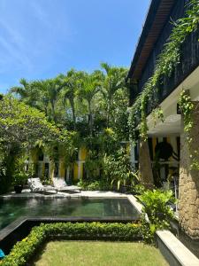 a garden with a pool in front of a building at Amanputri Villa in Seminyak