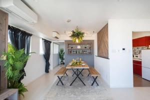 a dining room with a table and a kitchen at The Penthouse Ginowan in Makiminato