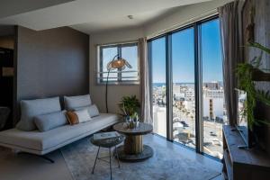 a living room with a couch and a large window at The Penthouse Ginowan in Makiminato