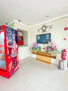 Zimmer mit einer roten Koksmaschine und einem TV in der Unterkunft OYO 90709 Northern Inn 