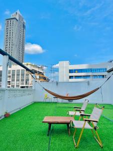 een hangmat en stoelen op het dak van een gebouw bij Daraya Hostel in Bangkok