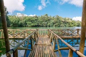 Almost Heaven Lake Resort by Cocotel في غافيتي: جسر خشبي فوق جزء من الماء