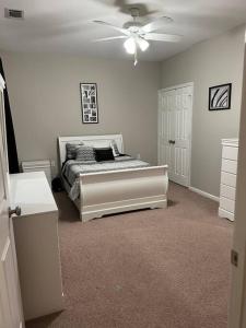 Schlafzimmer mit einem Bett und einem Deckenventilator in der Unterkunft Cheerful 3 bedroom, close to downtown and arena!!! in Savannah