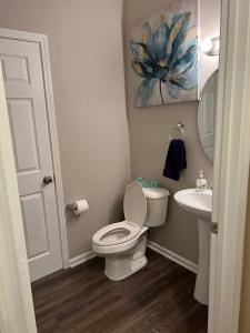 a small bathroom with a toilet and a sink at Cheerful 3 bedroom, close to downtown and arena!!! in Savannah