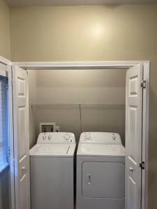 a laundry room with two washes and a washer and dryer at Cheerful 3 bedroom, close to downtown and arena!!! in Savannah