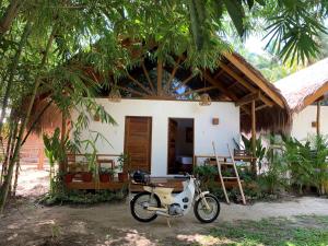 ein Motorrad, das vor einem Haus geparkt ist in der Unterkunft G Villas Siargao in General Luna