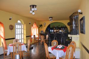 un comedor con 2 mesas y un bar en Hotel Pod Dębami, en Pabianice