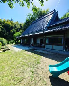 una casa con un banco verde delante de ella en 楓 -Kaede-, en Ōuda