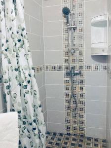a bathroom with a shower with a shower curtain at Maison a Bourg- Murat proche de la cité du volcan in La Plaine des Cafres