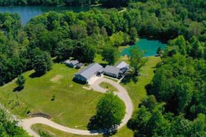 an aerial view of a house on a farm next to a lake at The Sanctuary 14 acres w/pond/fishing/trails/etc. in Nashville