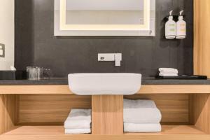 a bathroom with a sink and a counter with towels at Furama Darling Harbour in Sydney