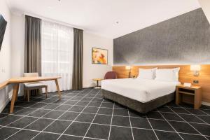 シドニーにあるFurama Darling Harbourのベッドと机があるホテルの部屋