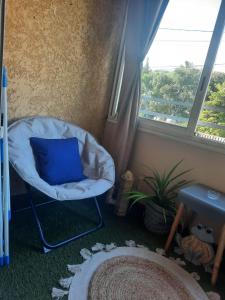 サン・ジョゼフにあるAnaïs 2の窓のある部屋で、椅子と青い枕が備わります。