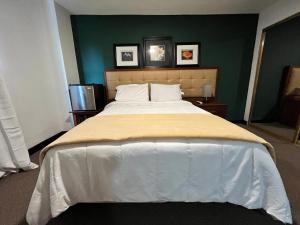 duże łóżko w sypialni z zieloną ścianą w obiekcie SJ SUITES HOTEL w mieście San Juan