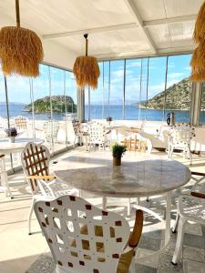 a room with a table and chairs and the ocean at Liman Hotel Gümüslük - Adult Only in Bodrum City