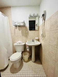 a bathroom with a toilet and a sink at SJ SUITES HOTEL in San Juan