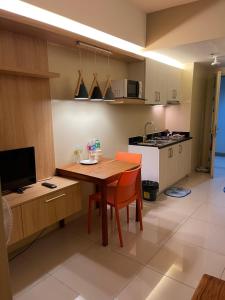 a kitchen with a wooden table and a kitchen with a stove at Netflix- Destina Stays at Jazz Residences Makati, MetroManila in Manila