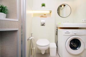 ein Badezimmer mit einer Waschmaschine und einem Waschbecken in der Unterkunft уютная квартира-студия в центре Алматы in Almaty