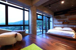een slaapkamer met een groot bed en grote ramen bij Revika B&B in Yuemei
