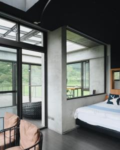 een slaapkamer met een bed en grote ramen bij Revika B&B in Yuemei
