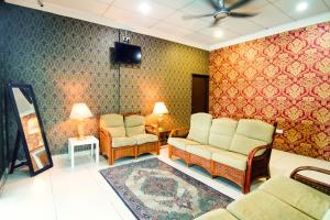 a waiting room with two chairs and a tv at OYO 528 Andaman Sea Hotel in Batu Ferringhi