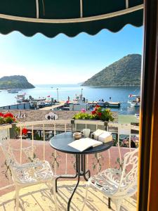 a table and chairs on a balcony with a view of the beach at Liman Hotel Gümüslük - Adult Only in Bodrum City