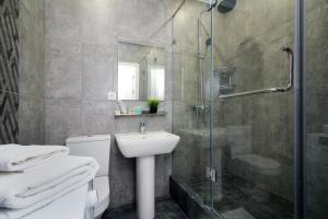 a bathroom with a shower and a sink and a toilet at Светлая квартира in Almaty
