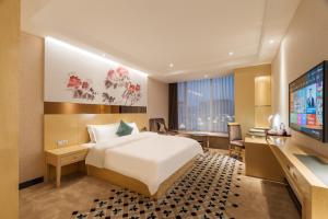 a hotel room with a bed and a flat screen tv at Paco Hotel Suyuan Metro Guangzhou in Guangzhou