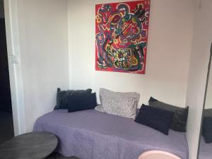 a bedroom with a purple bed and a painting on the wall at Ofir, nice small unit, 123Eilat in Eilat