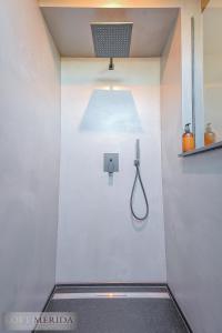 y baño con ducha y luz en la pared. en Loft Merida - Designer Apartment with Large Bathtub, en Bütgenbach