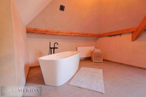 un bagno con una grande vasca bianca in mansarda di Loft Merida - Designer Apartment with Large Bathtub a Butgenbach