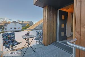 un balcón con mesa y 2 sillas. en Loft Merida - Designer Apartment with Large Bathtub, en Bütgenbach
