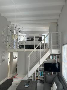 a living room with a staircase with a bed in it at Cozy Corner Cottage in Langebaan