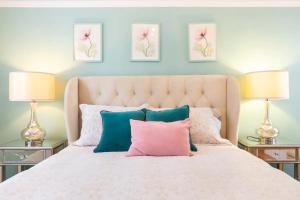 サンフランシスコにあるBeautiful Home with Sun-Drenched Garden, 2 BR,1 BA ,laundry, parking, Potrero Hill location, modern aestheticのベッドルーム1室(ピンクとブルーの枕が付いた白いベッド1台付)