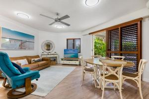 a living room with a table and chairs and a couch at Raffles Mooloolaba in Mooloolaba