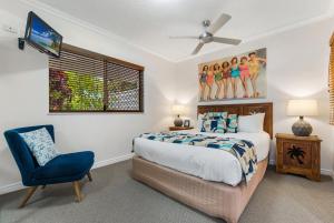 a bedroom with a bed and a blue chair at Raffles Mooloolaba in Mooloolaba
