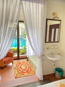 uma casa de banho com uma cama, um lavatório e uma janela em Casugria Dutch Residence 1810 em Malaca
