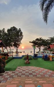 vista para a piscina num resort com o pôr-do-sol em Penny's Resort em Ko Chang