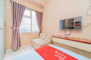 SumedangにあるRedLiving Apartemen Easton Park Jatinangor - Rajes Roomの小さな客室で、テレビ、ソファが備わります。