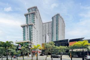 un grande edificio in una città con palme di RedLiving Apartemen Easton Park Jatinangor - Rajes Room a Sumedang